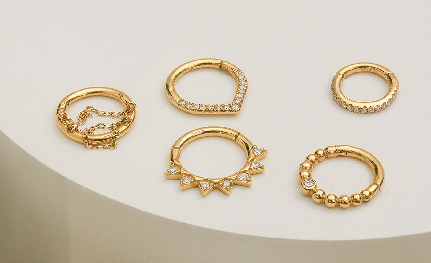 Stunning 14k gold earrings showcasing unique designs and precious stones, artistically arranged on vibrant macaroon cookies, perfect for a chic accessory display.