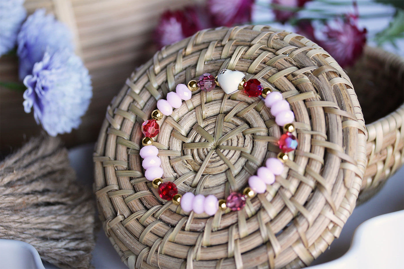 Swarovski Crystal Elements - White Enamel Heart, Multicolor Stretch Bracelet on basket surrounded by flowers. 
