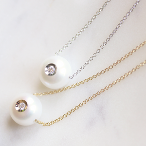 Galatea white freshwater pearl pendant featuring an inset diamond, set in yellow and white gold, displayed on a clean white background.