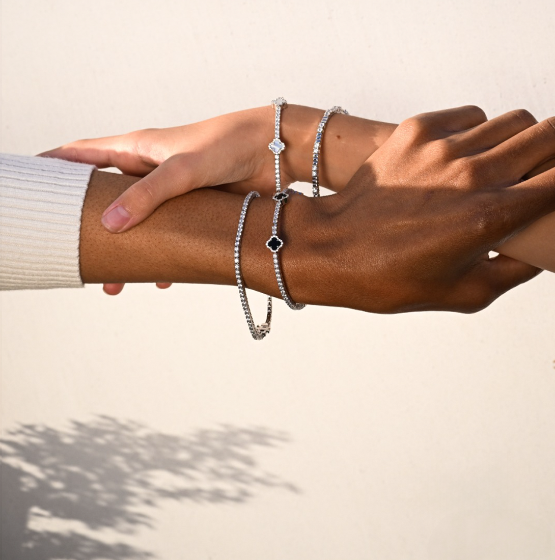Lafonn sterling silver and simulated diamond tennis bracelets displayed on diverse hands, showcasing elegant and timeless fine jewelry against a soft neutral background.