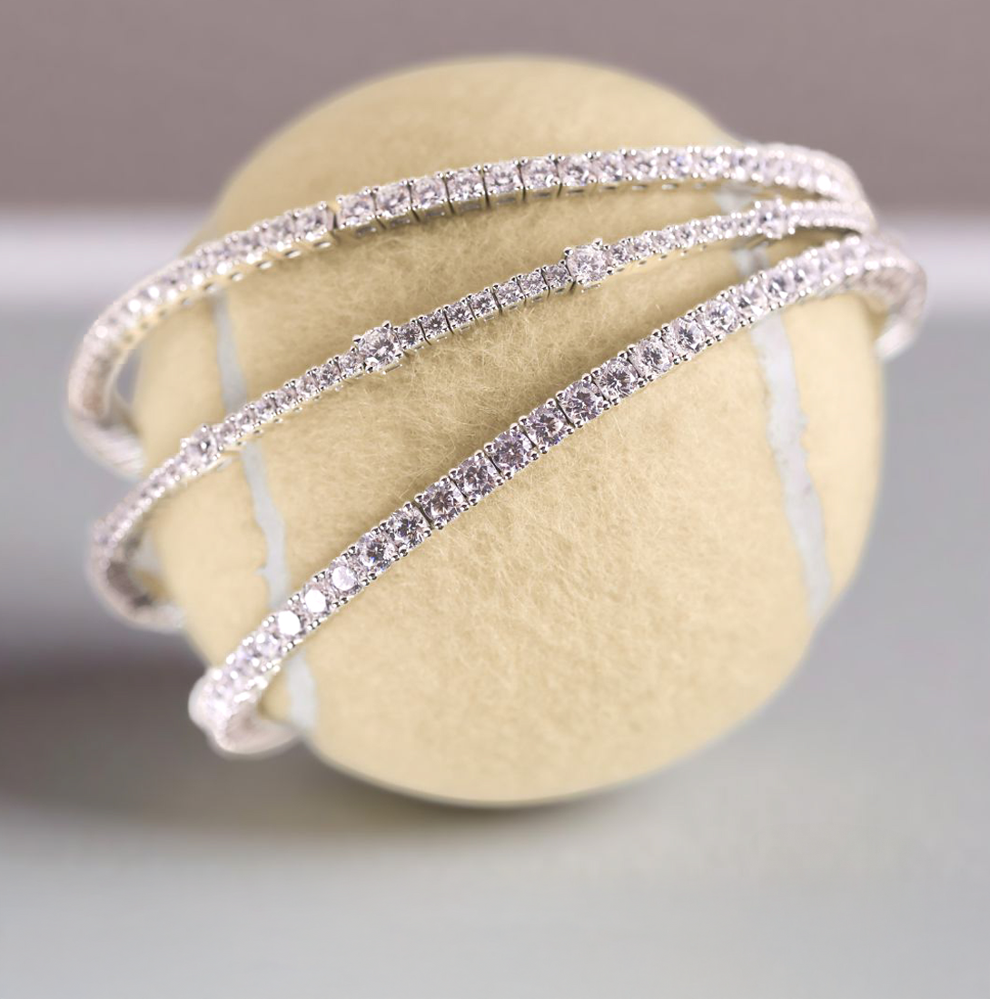 Lafonn simulated diamond tennis bracelets in sterling silver, elegantly wrapped around a tennis ball. Timeless and sparkling tennis bracelet designs that bring everyday luxury and classic style.