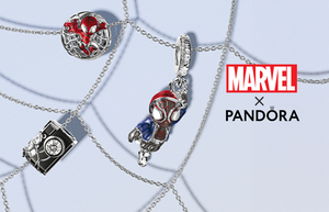 Marvel x Pandora jewelry collection featuring Spider-Man-themed sterling silver charms, including a red enamel Spider-Man face, Miles Morales swinging charm, and a detailed camera charm, displayed on delicate silver chains over a web-inspired background.