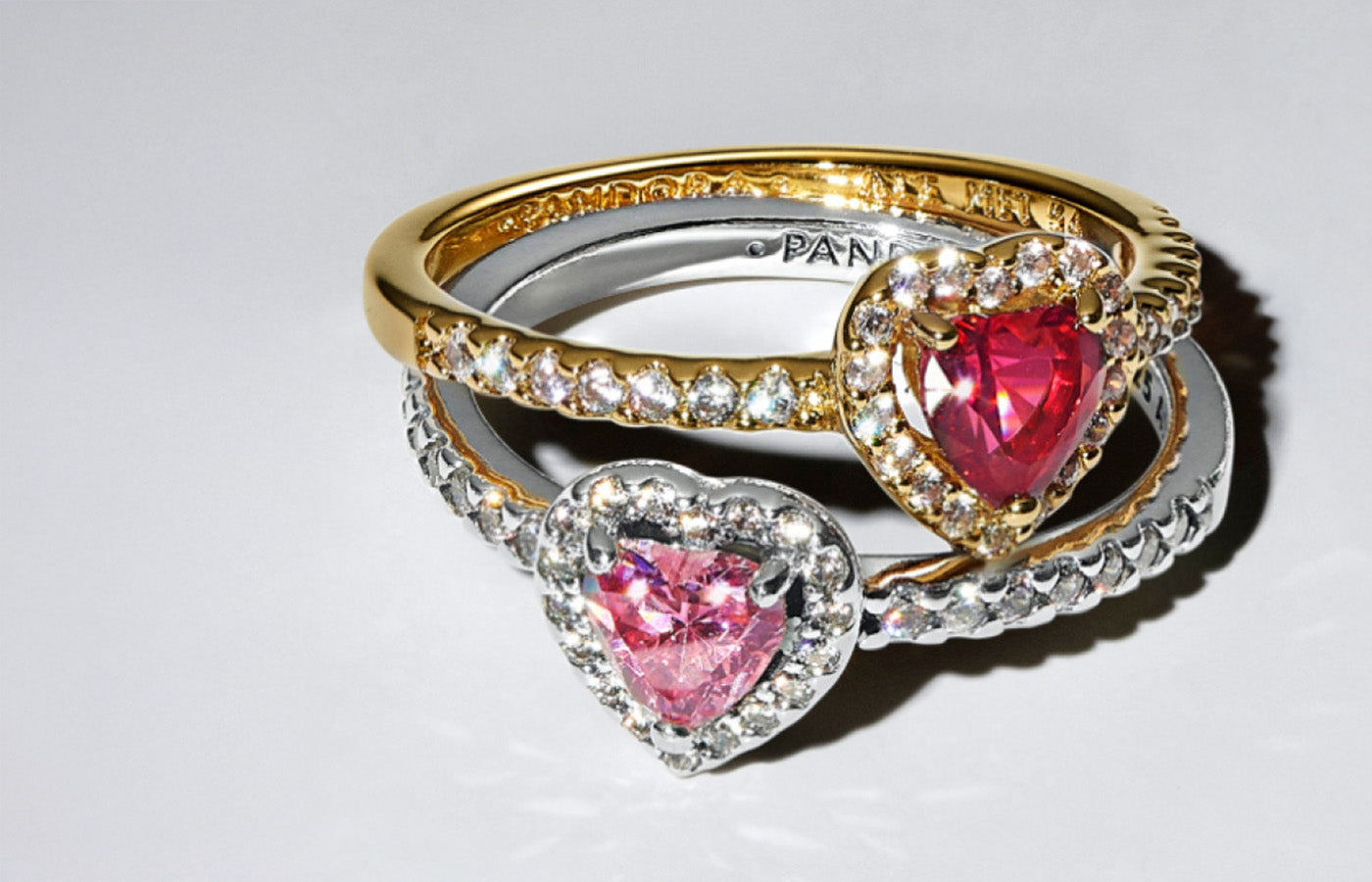 Pandora heart-shaped rings in sterling silver and gold tones, featuring pink and red center stones with pavé accents. New arrivals from Pandora jewelry—romantic and stackable styles for the season.