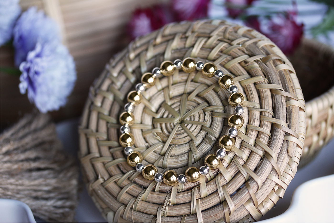 sSunning alternating mixed-metal stretch bracelet features alternating 6mm 14k Gold-filled and 4mm sterling silver beads on basket surrounded by flowers. 