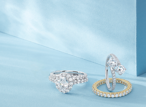 Radiant white gold and gold engagement rings with stunning diamond wedding bands on a teal background, featuring beautiful shadows - where your 'I do' comes true.